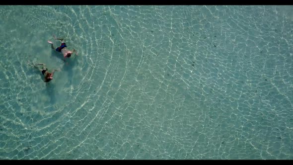 Man and woman tan on beautiful shore beach break by blue sea and bright sand background of the Maldi