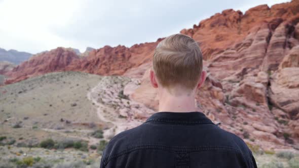 Slow motion shot of the back of young caucasian man walking in Red Rock Canyon National Conservation