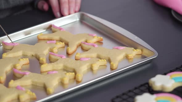 Step by step. Decorating unicorn sugar cookies with royal icing on baking sheet