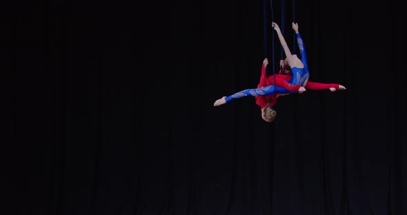 Graceful Aerial Gymnastics Performance Above the Stage Two Girls Flexible