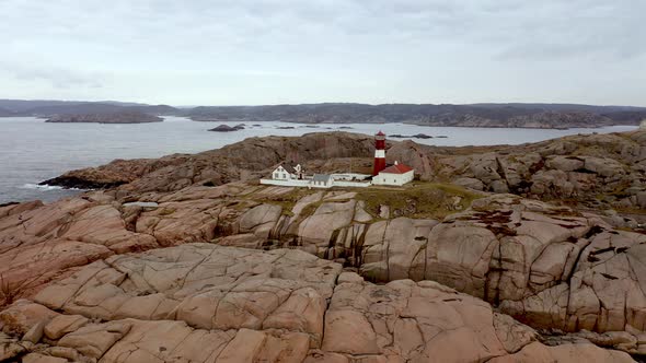 Slow moving low altitude aerial showing coastal landscape and archipelago with Ryvingen lighthouse a