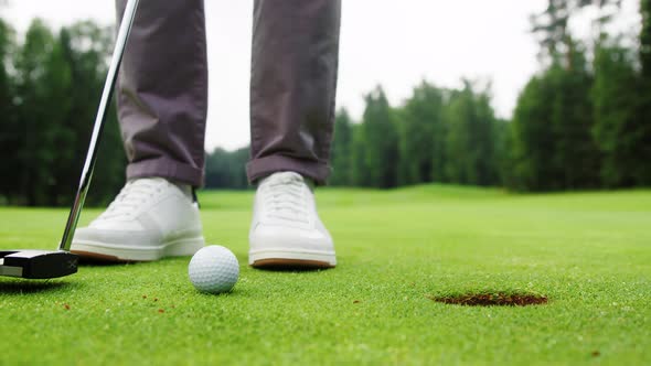 Young man in white shoes making a hit with a golf club