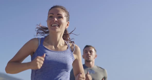 Tracking Slow Motion Shot of Sportive Couple Jogging Outdoors in the Morning Trail Running