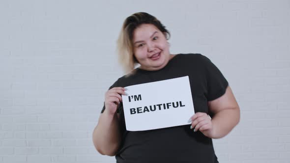 Concept Body Positivity an Overweight Smiling Woman Dancing and Holds a Sign with the Inscription I
