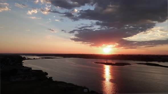 Reveal a brilliant golden sunrise reflecting off Moses Lake, Washington, aerial