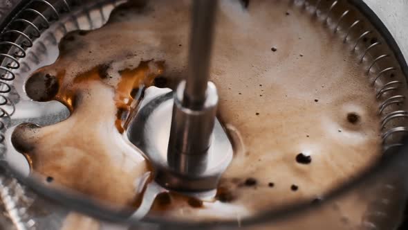 Coffee Running Through a French Press As It Plunges Down