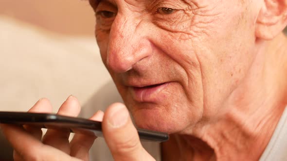 Portrait of a Caucasian pensioner 70 years old talking on a smartphone.