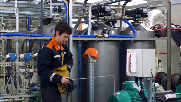 An Employee in Overalls is Preparing for Hazardous Work Associated with the Risk of Toxic Fumes in