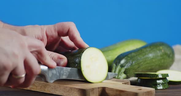 Man's Hand Crushed Ripe Zucchini with a Knife. 