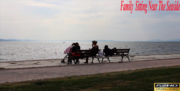 Family  Sitting Near The Seaside