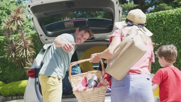 Happy caucasian couple with son packing car and preparing for holiday