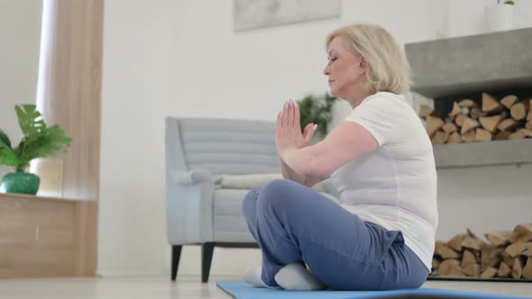 Close Up of Old Woman Meditating on Yoga Mat at Home