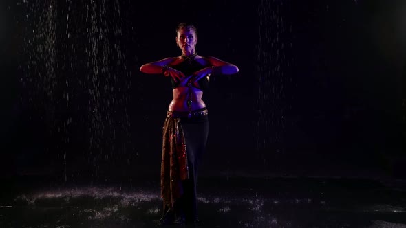 Mysterious Belly Dancer Woman is Standing Under Rain in Darkness Fulllength Shot