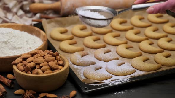 Woman Sprinkles Sugar Powder on Traditional German or Austrian Vanillekipferl Vanilla Kipferl