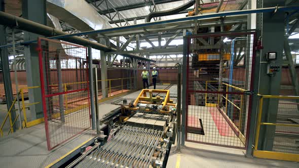 Engineers Check Machines Working with Bricks at a Plant.