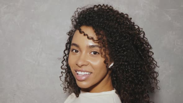 Beautiful black woman with afro curls hairstyle posing in studio