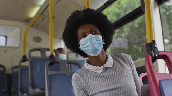 African american businesswoman with face mask sitting in bus