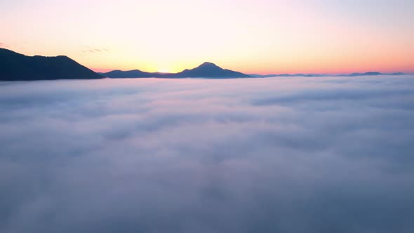 4K Aerial video Beautiful sunrise above dense clouds and fog in the morning