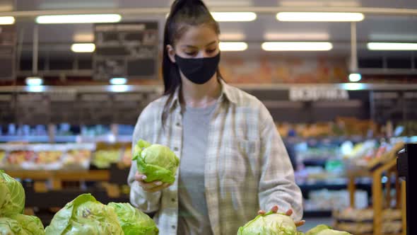 Woman Choosing Fresh Cabbage in Supermarket