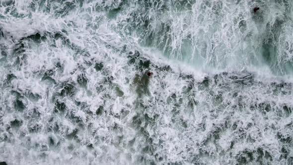 Aerial Birds Eye View Of Female Tourist Swimming Under Waves Off Nai Harn Beach. Pedestal Up