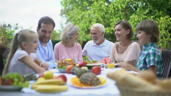 Big Family Talking During Dinner Outdoors, Enjoying Time Together, Celebration