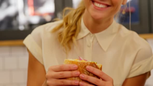 Portrait of female executive having burger 4k