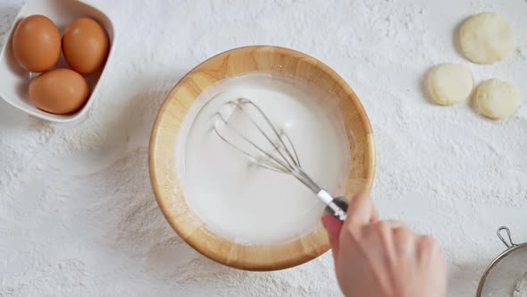 Hand stirring pouring and cups for flour on the table with for making various desserts