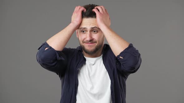 Portrait of Trouble Man in Casual Clothing Grabbing His Head in Panic and Expressing Hopelessness or