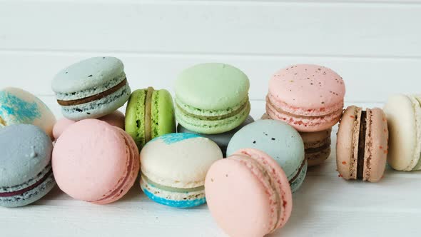 Man Puts Macaroons or Macarons in a Pile of Almond Cookies