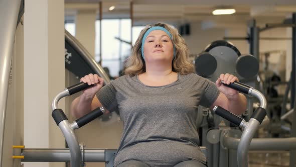 Woman Doing Fitness Exercises on Chest Press Machine at the Gym