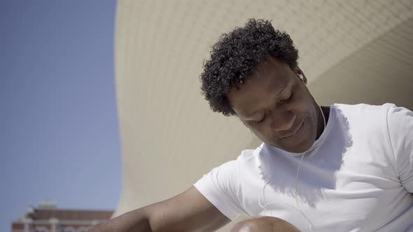 Smiling African American Man Listening Music with Earphones