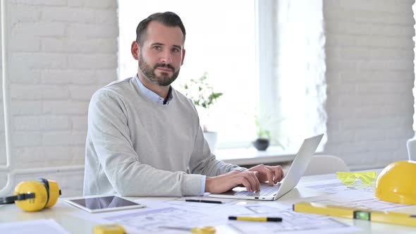 Positive Young Architect with Laptop Doing Thumbs Up in Office