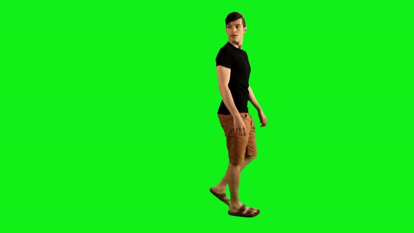 A Young Man Walking Over a Green Screen, Looking Back Happily