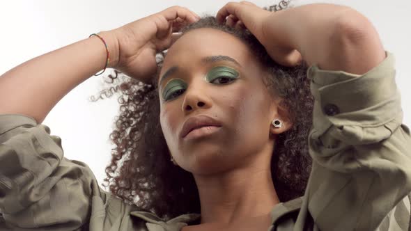 Young Mixed Race Model in Studio on White with Curly Hair, Bright Green Eye Makeup