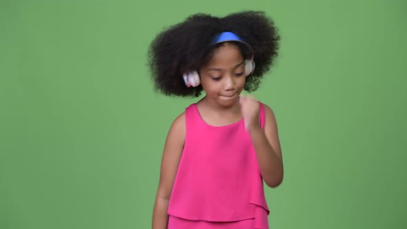 Young Cute African Girl with Afro Hair Listening To Music