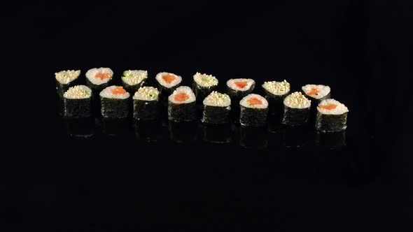 Sushi with Chopsticks Over Black Background