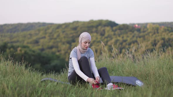 Muslim Woman in Hijab Tying Laces on Sport Sneakers Before Morning Run at Green Park