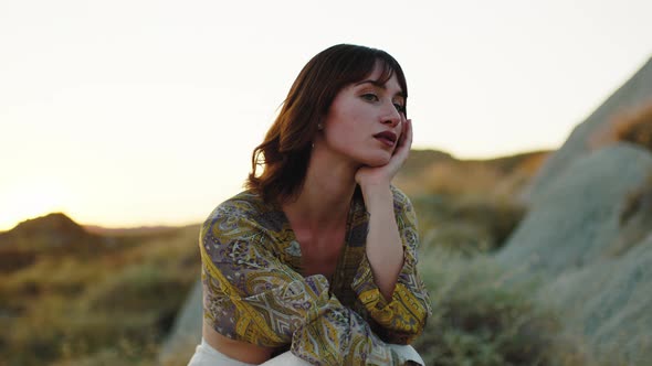 Sad Girl Sitting on a Lonely Rock in Summer