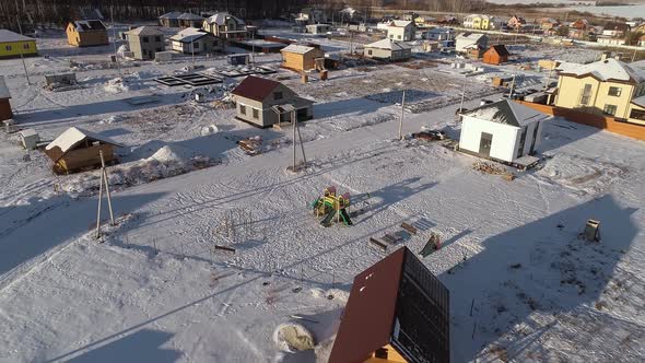 Aerial view of small kid games playground in winter cottage village. 06