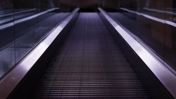 Empty Moving Walkway with Shiny Glass Handrails in Dark Hall