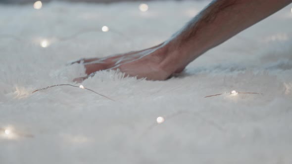 Hand is touching a soft white carpet