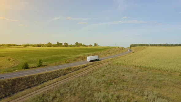 semi truck driving on a highway into the sunset. 