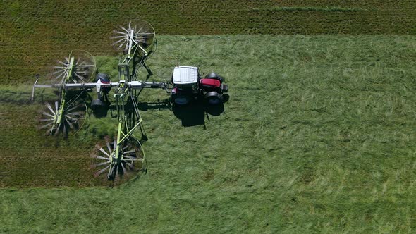 Aerial view of a tractor mowing a green grass field