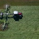 Aerial view of a tractor mowing a green grass field - VideoHive Item for Sale