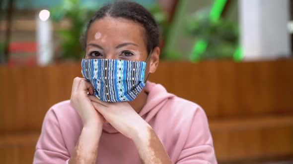 Black African American Woman with Vitiligo Pigmentation Skin Problem Indoor Dressed Pink Hoodie and