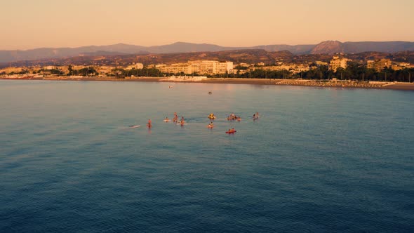 Silhouette of People Training Stand up Paddle at Sunrise