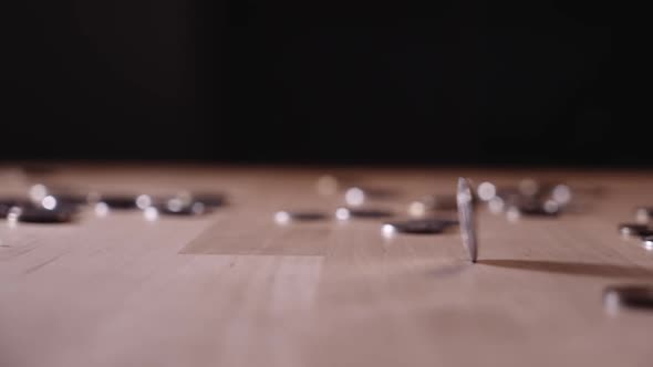 the coin is spinning on the table among the coins