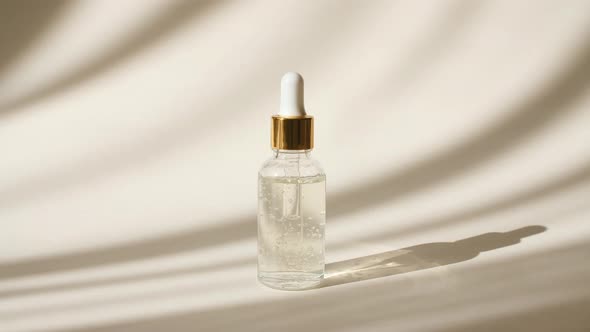 Skin Care Cosmetic Oil Serum Bottle on Beige Background in the Morning Rays of Light and Shadows
