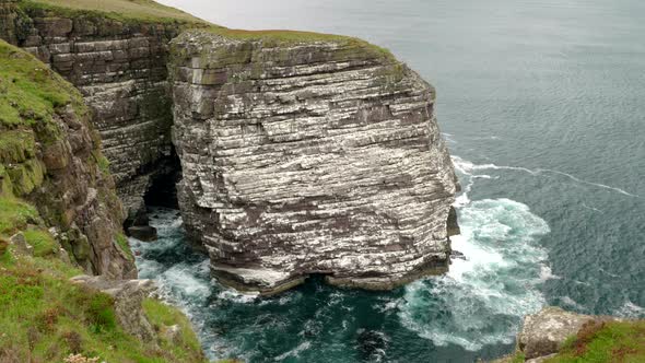 Breathtaking view of a sea cliff and the great sea stack of Handa Island covered in a bustling seabi