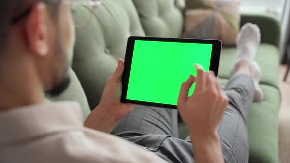 Rear View on Green Screen Over Shoulder Man Typing on Tablet